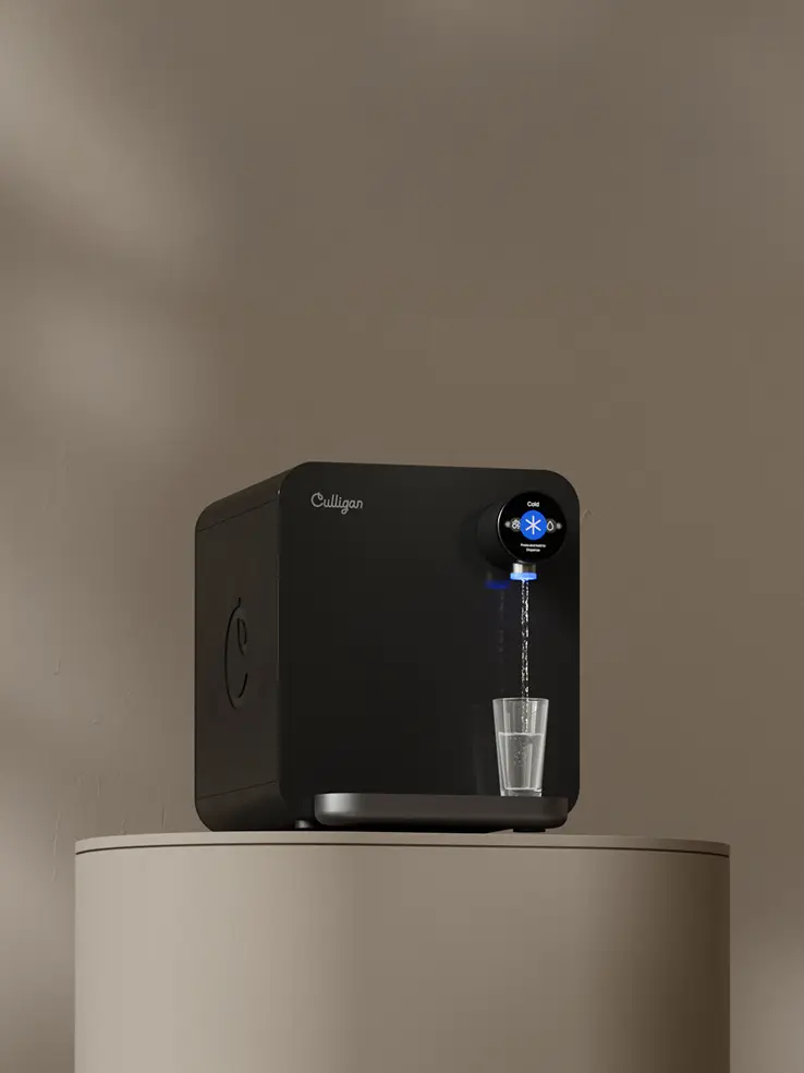 The Purity Prime countertop unit, a black dispenser with a round display beside the spout, standing on its own base.
