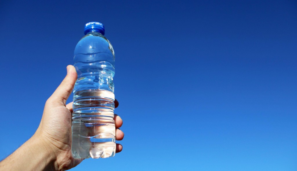 person holding up bottled water