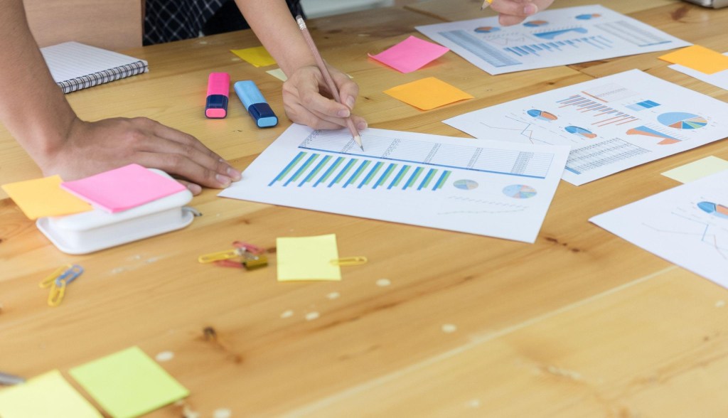 people doing paperwork with sticky notes