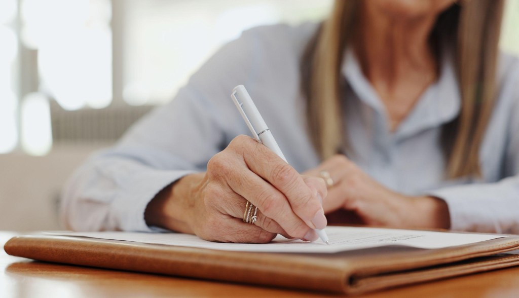 woman working while writing something down