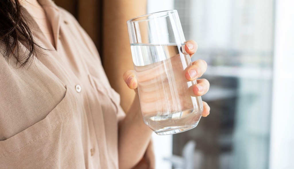 Woman holding glass of water