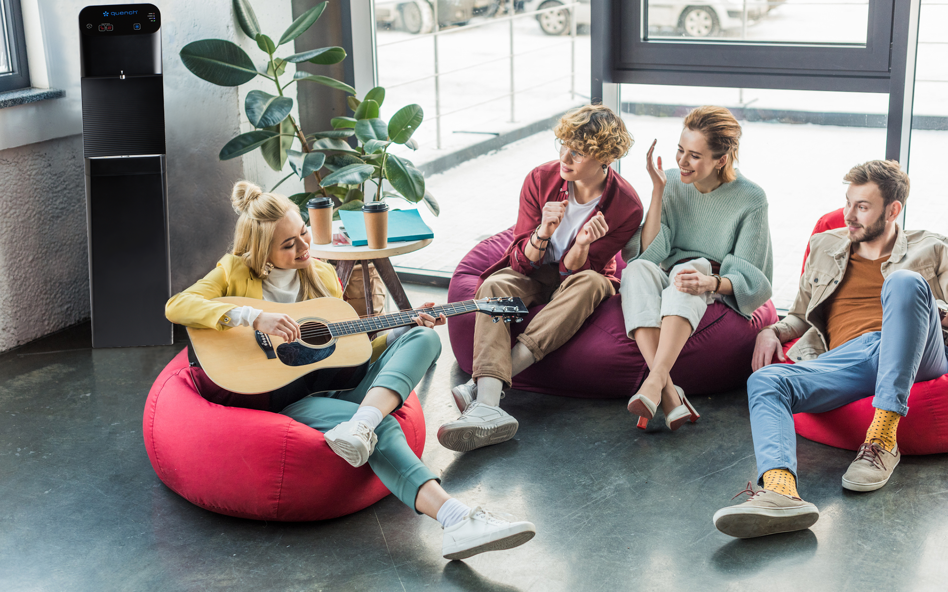 Employees gathering around a bottleless water cooler in a break room.