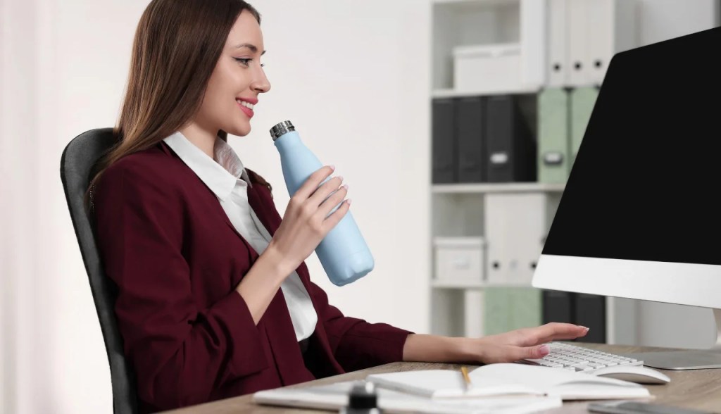 woman working drinking water from water bottle