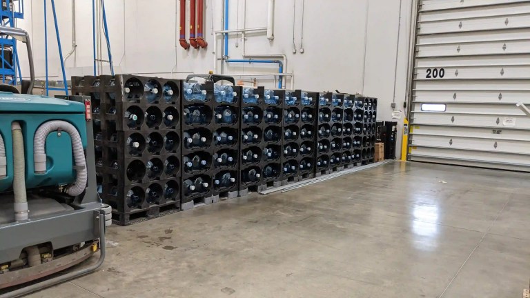 Stack of 5-gallon water jugs in a warehouse