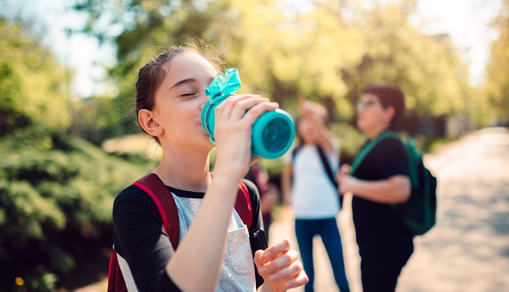 kid drinking from water bottle outside