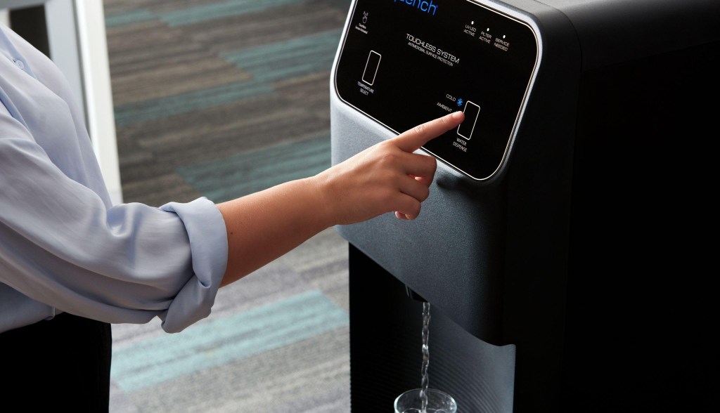 hand touching bottleless water cooler filling up water