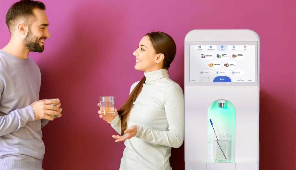 man and woman talking next to sparkling water cooler