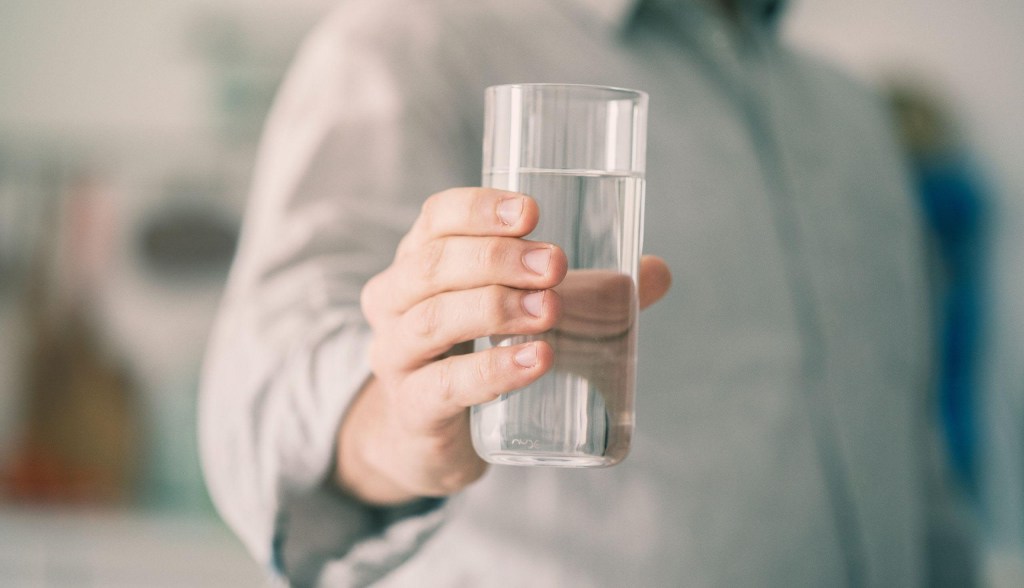 person holding glass of water