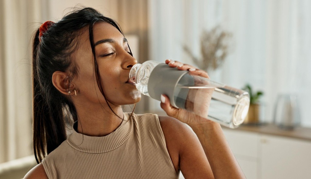 woman drinking from water bottle