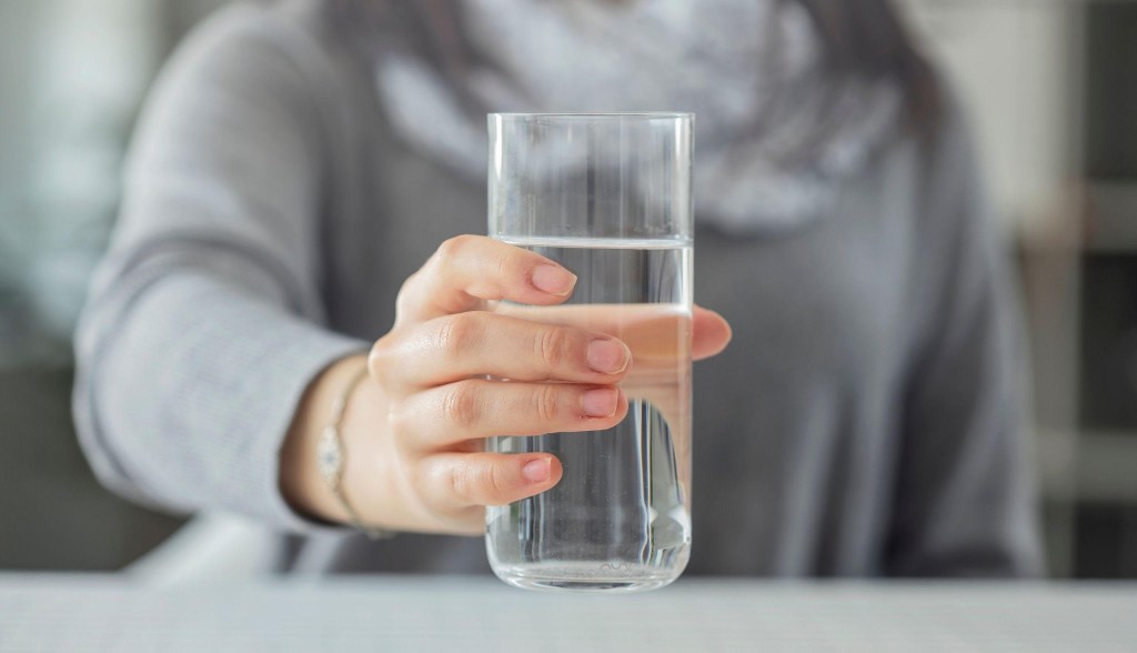 woman holding water glass