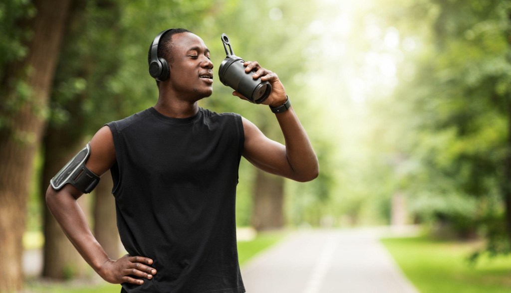 man exercising and drinking water outside