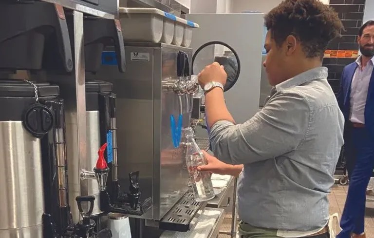 restaurant worker dispensing water from vero water dispenser