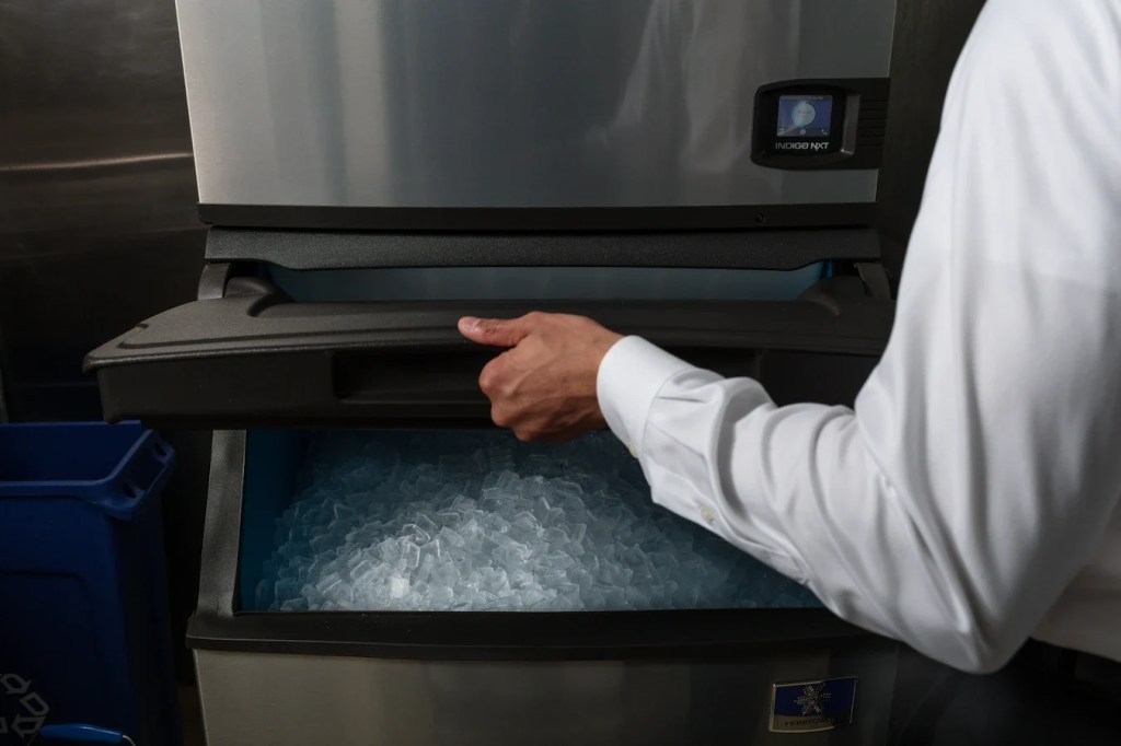 Person lifting up an bin ice machine with one hand