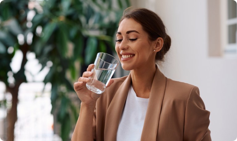 Woman smiling while holding a glass of water