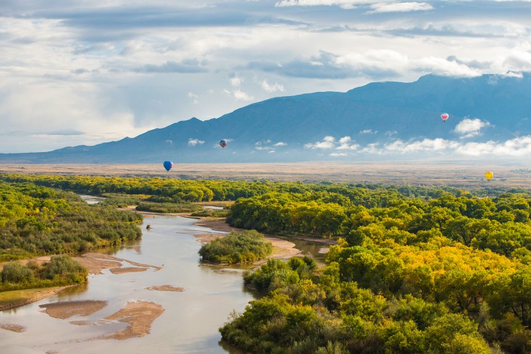 Air balloons flying over river in Albuquerque