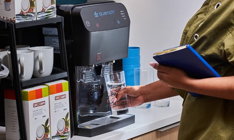 woman dispensing water from q5 water cooler in break room