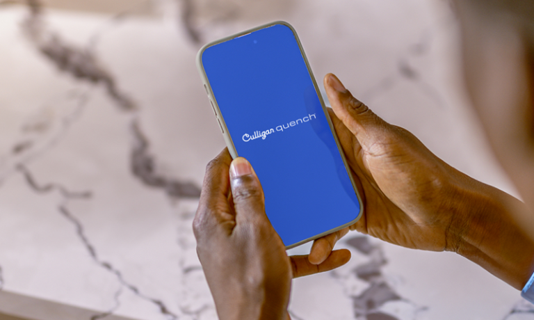 person holding phone looking at culligan quench app