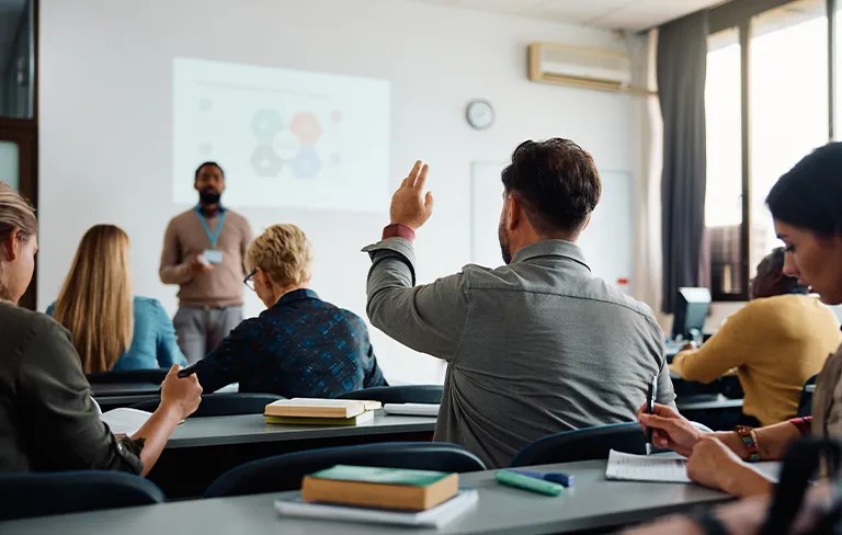 student raising hand in a classroom