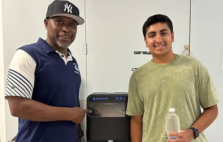 Man and boy standing next to a Q12 bottleless water cooler