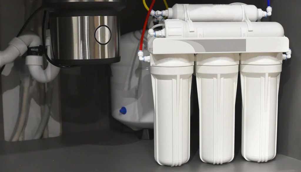 white under-sink water filter system under a sink