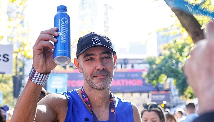 Man raising up an aluminum bottle of Culligan water