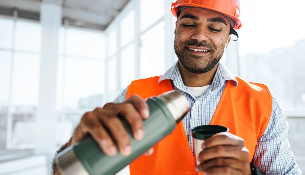 field worker pouring water into tumbler
